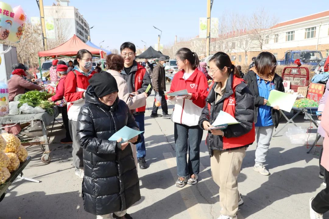 1710147447918968.jpg 3.团场志愿者们为大巴扎上来往的职工群众普及反电信网络诈骗、道路交通安全、民法典等知识。.jpg