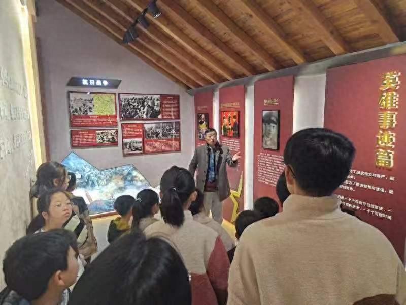 35名中小学生在家长的陪同下，正在认真聆听一老一小“红色故事宣讲员”讲史家村故事1.jpg