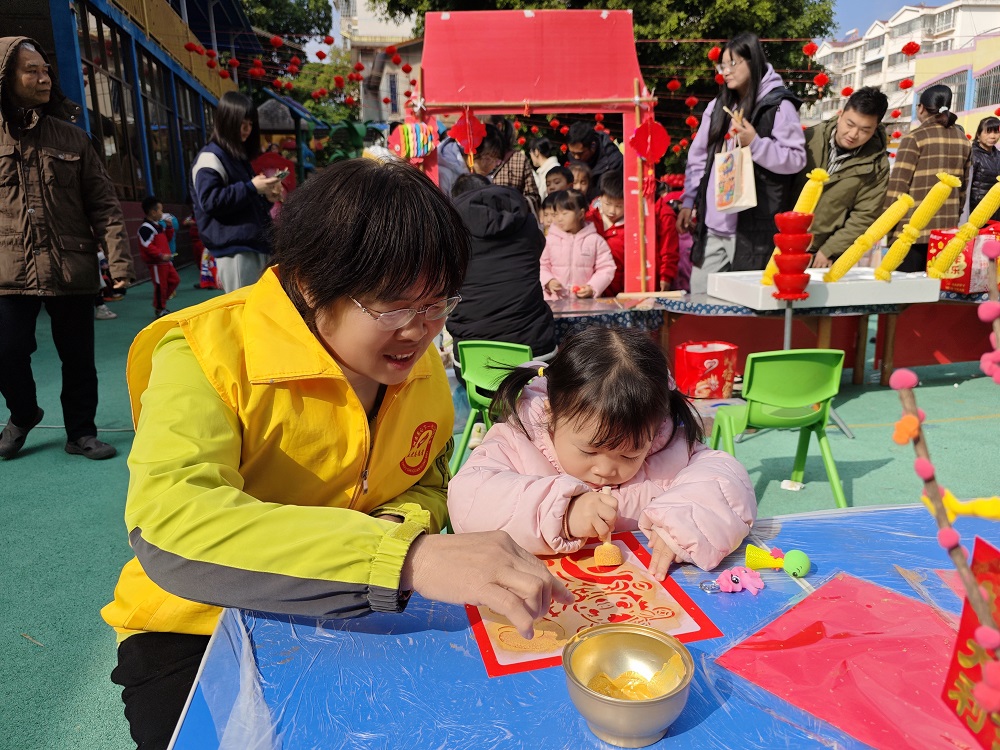 【非遗庙会迎新春  传统文化润童心】“五老”志愿者协助小朋友拓印吉祥图案1.jpg