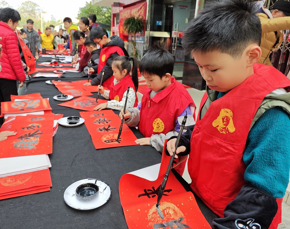 1770623347601380.jpg 【龙擎苑社区年味浓!游园、市集、文艺汇演…居民家门口乐享新春】小志愿者们为辖区居民免费写春联送福1.jpg