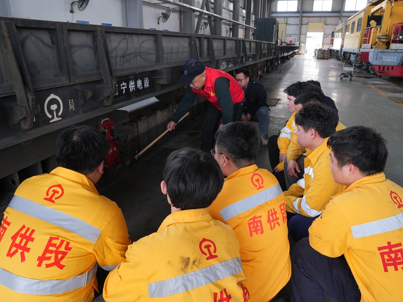 1773929661976575.jpg 图为段“五老”陆建辉给青年职工讲解车辆检修技能.jpg