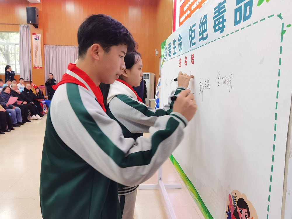 1709024253361695.jpg 学生代表在禁毒板上签字1.jpg