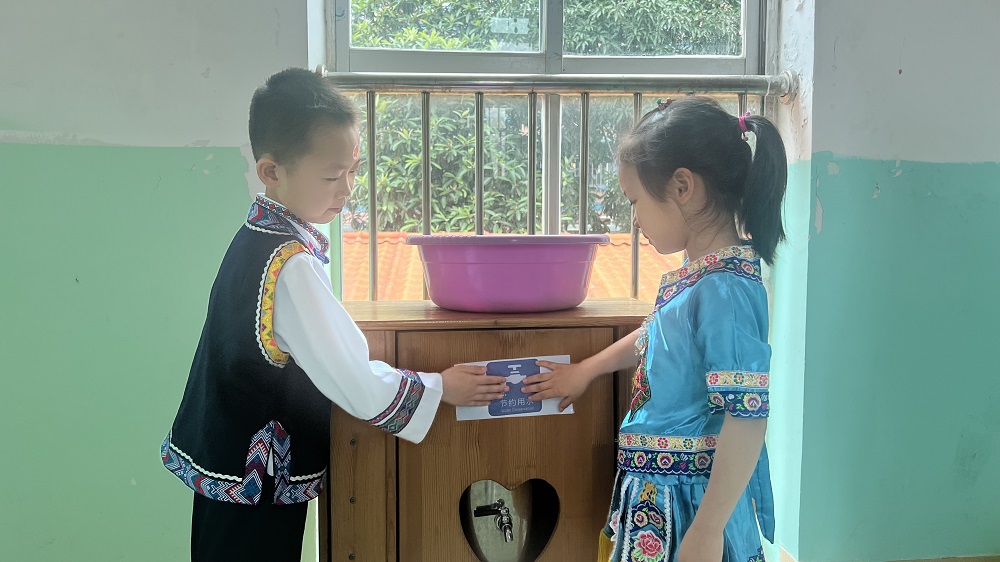 燎原幼儿园小朋友们进行节约用水情景剧，将节约用水标识张贴在打水处1.jpg