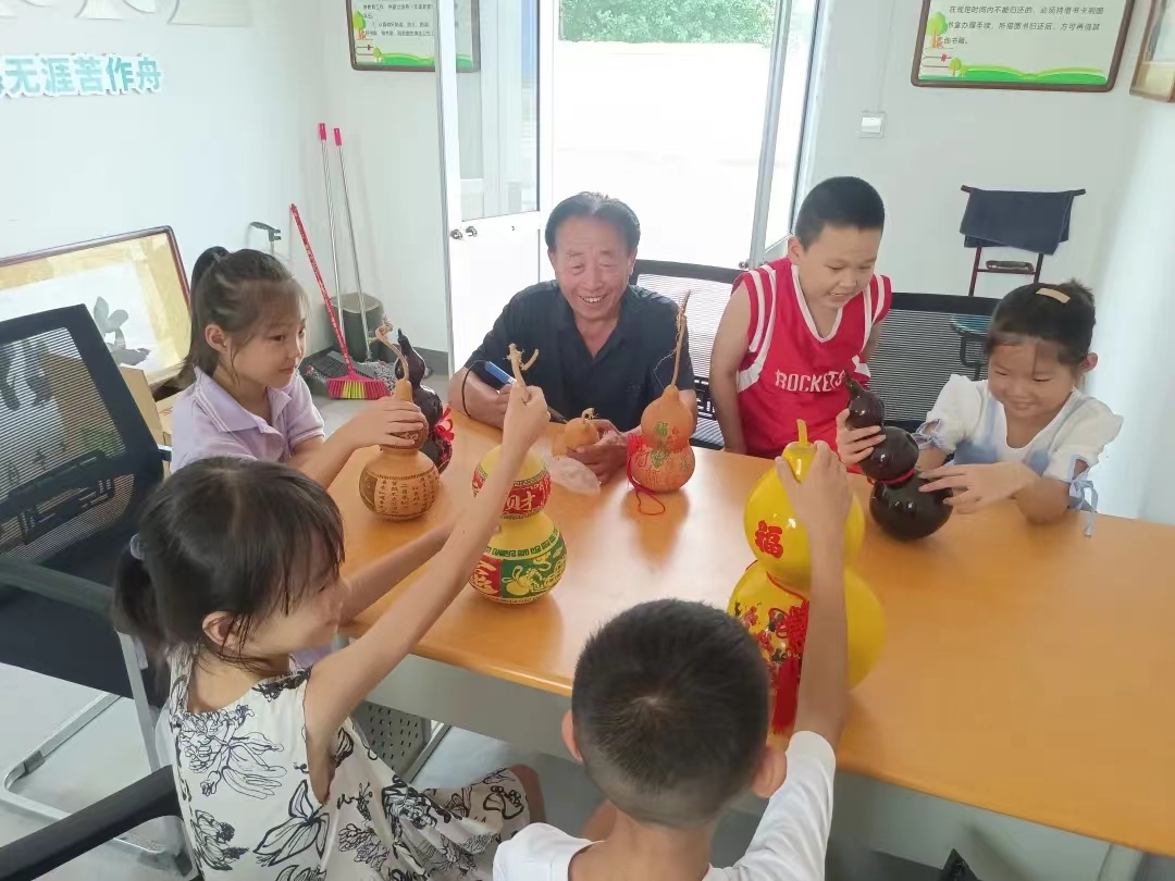 1723425319380502.jpg 1.葫芦雕刻爱好者孟召君老人向孩子们演示葫芦雕刻方法和技巧.jpg