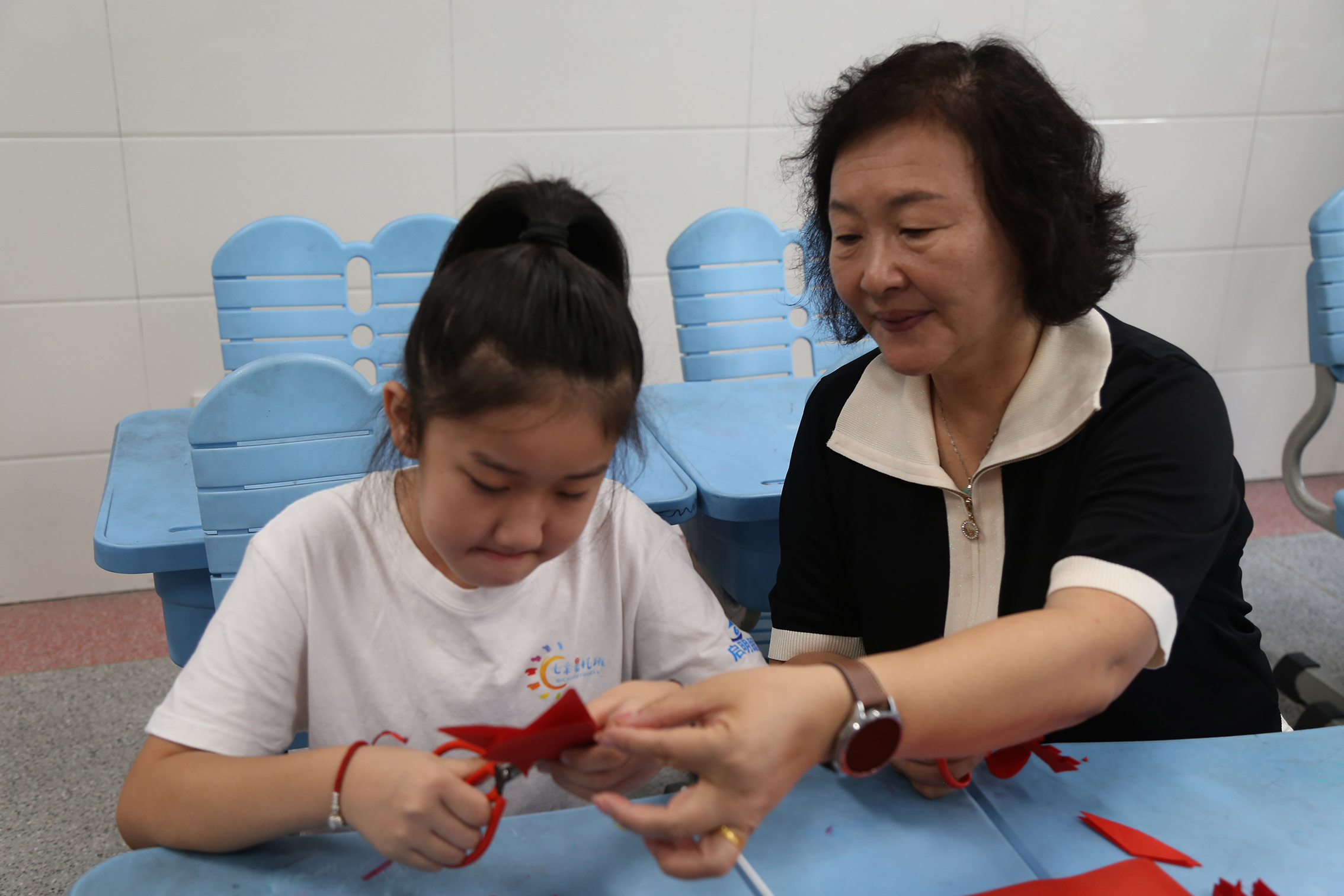 济宁市关工委常务副主任倪丽君在任城区七彩暑托班与青少年一起体验非遗剪纸技艺.jpg