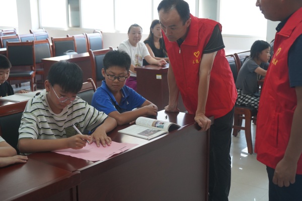 1724663094804669.jpg 4.志愿者引导未成年人在承诺书上签字.jpg