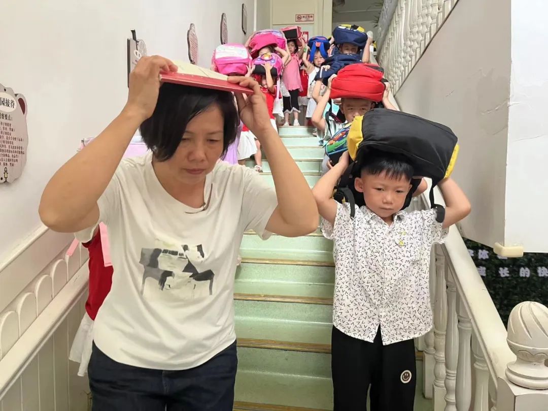 1726825405974569.jpg 幼儿和老师护住重要部位有序下楼.jpg