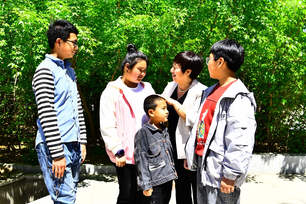 1738574329816565.jpg 张玉梅与青少年学生 和幼儿在一起谈话.jpg