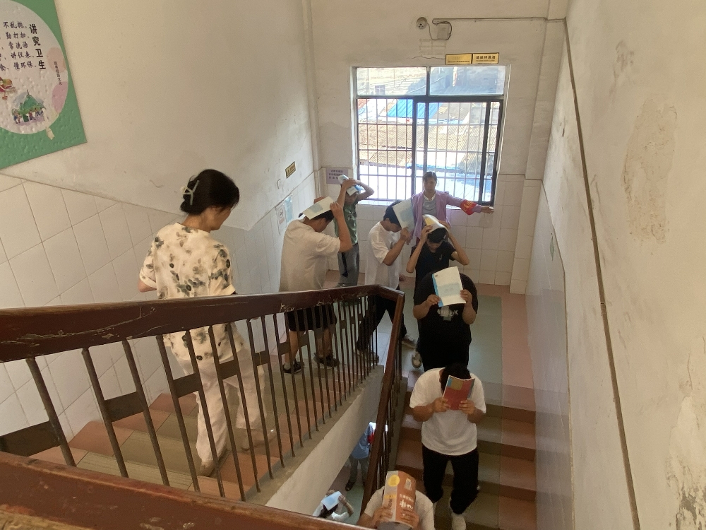 1747044477678445.jpg 在各个楼梯口、拐角处等关键位置,都有社区工作人员和老师负责维持秩序.jpg