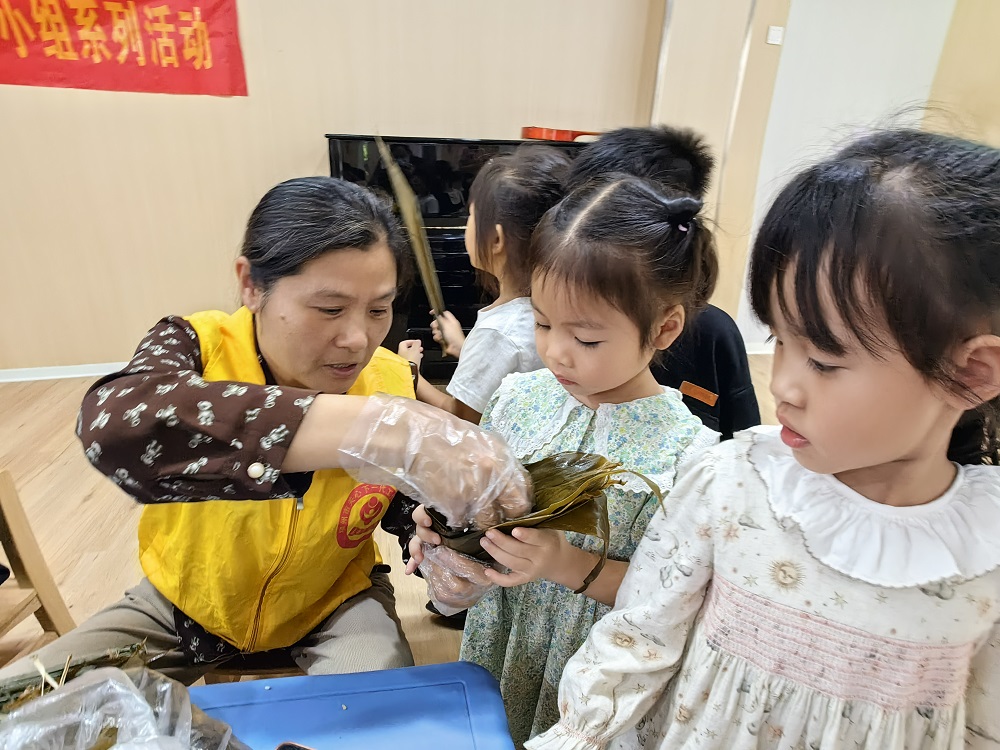 1748343045441603.jpg “五老”志愿者指导幼儿包粽子.jpg