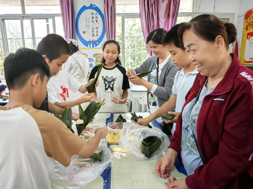 1748514566172984.jpg 广西柳州市鱼峰区天山社区关工领导小组开展“粽香满校园 端午情绵长”端午节包粽子活动1.jpg
