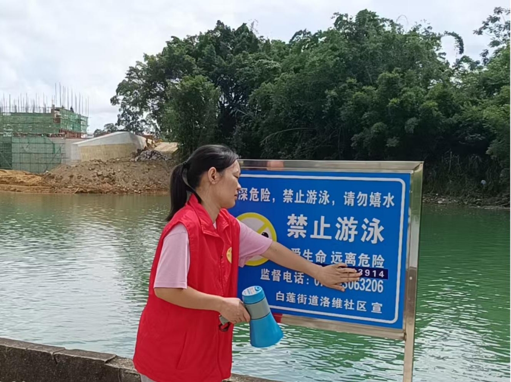 1751531668512028.jpg 社区工作人员利用喇叭循环播放防溺水提醒,并检查警示牌是否损坏.jpg