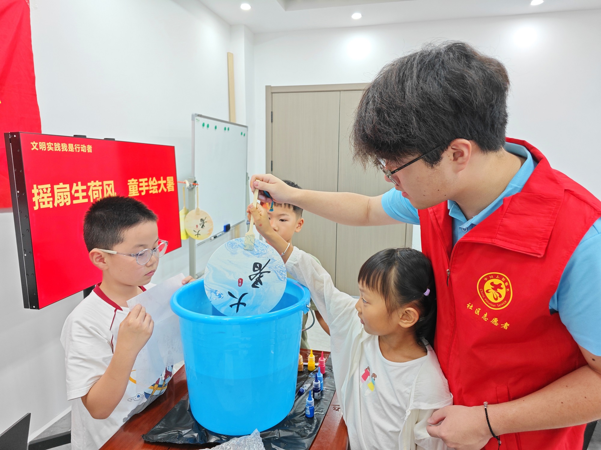 孩子们在大学生志愿者的指导下，制作独一无二的漆扇.jpg